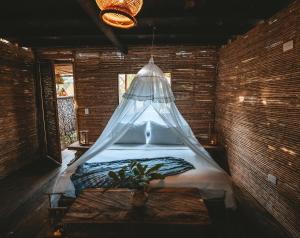 a bedroom with a bed with a mosquito net at Isla Fuerte Eco House in Puerto Limón
