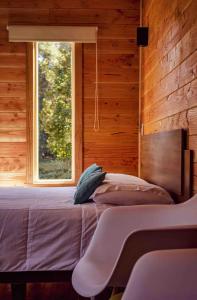 1 dormitorio con cama y ventana en Tiny House con opción de tina temperada, en Puerto Varas