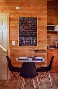 a table in a kitchen with a menu on the wall at Tiny House con opción de tina temperada in Puerto Varas