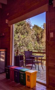 una veranda riparata con tavolo e sedie su una terrazza di Tiny House con opción de tina temperada a Puerto Varas