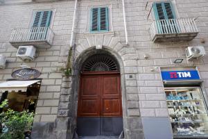 un edificio in mattoni con una porta in legno e un negozio di Boutique Toledo a Napoli
