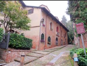 San Colombano al Lambro的住宿－Bed & Breakfast Monti 85，前面有标志的砖砌建筑