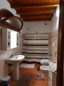 y baño con 2 aseos, lavamanos y ducha. en Bed & Breakfast Monti 85 en San Colombano al Lambro