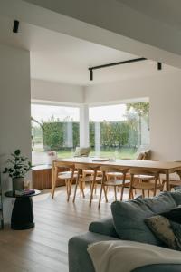 sala de estar con mesa de madera y sillas en MAM Haspengouw, en Sint-Truiden