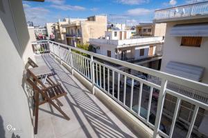 einen Balkon mit einem Stuhl und Stadtblick in der Unterkunft 'Ariadni' Elegant Residence in Athen