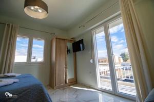 ein Schlafzimmer mit einem Bett und einem großen Fenster in der Unterkunft 'Ariadni' Elegant Residence in Athen