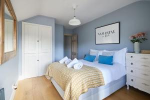 a bedroom with a large bed with blue walls at The Sea House Beautiful Large Whitstable Home With Sea Views in Kent
