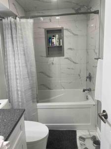 y baño con bañera blanca y aseo. en Luxurious & upscale basement apartment, en Brampton