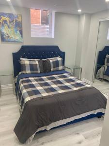 Un dormitorio con una cama azul y blanca con almohadas en Luxurious & upscale basement apartment, en Brampton