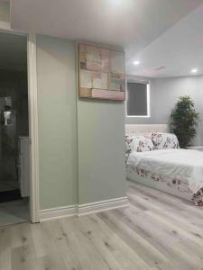 1 dormitorio con 1 cama y una pintura en la pared en Luxurious & upscale basement apartment, en Brampton