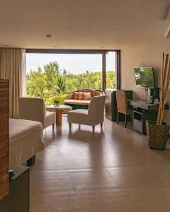 a bedroom with a living room with a large window at Las Flores Resort in Chirilagua