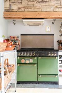 a green oven in a kitchen with a counter at Unique Willow Tree Bed in Quirky Home Stay Cottage, Near Holmfirth in Holmfirth