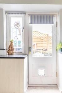 a white door with a cat sitting on a counter next to it at Unique Willow Tree Bed in Quirky Home Stay Cottage, Near Holmfirth in Holmfirth