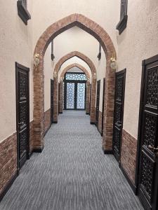 un couloir vide avec une arche dans un bâtiment dans l'établissement KHAMSA Tashkent Airport Hotel Sleep Lounge & Showers, Terminal 2 - TRANSIT ONLY, à Tachkent