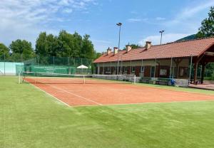 un court de tennis en face d'un bâtiment dans l'établissement Jodłowa Chata, à Myślenice