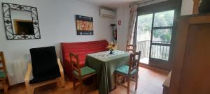 a dining room with a table and chairs and a window at VFT Castillo de la Yedra in Cazorla