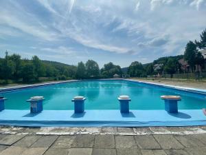 a large swimming pool with blue water at Jodłowa Chata in Myślenice