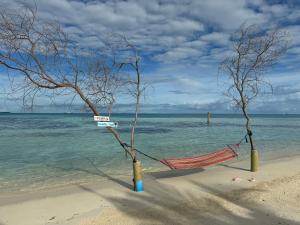 a hammock on a beach next to the water at Ithaa Hiya Dhihfushi in Dhiffushi