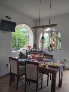 a dining room with a table and chairs and two windows at Finca Caracol in Bolulla