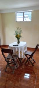 einen Tisch und zwei Stühle mit Vase drauf in der Unterkunft Casa de George in Urubamba