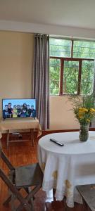 una sala de estar con una mesa con una foto en la pared en Casa de George, en Urubamba