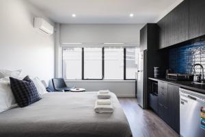 een slaapkamer met een groot bed en een keuken bij Hanover Apartment No 1 in Dunedin