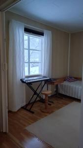 Zimmer mit einem Schreibtisch, einem Fenster und einem Bett in der Unterkunft Paritalokolmio joen rannalla in Haapavesi
