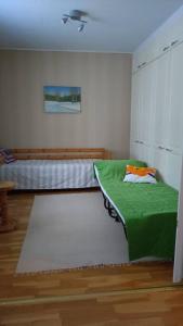 a bedroom with a bed and a green blanket at Paritalokolmio joen rannalla in Haapavesi