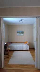 a bedroom with a bed and a white rug at Paritalokolmio joen rannalla in Haapavesi