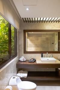 a bathroom with a sink and a toilet and a mirror at Las Flores Resort in Chirilagua