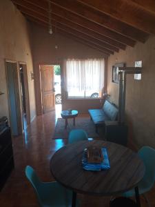 - un salon avec une table en bois et des chaises bleues dans l'établissement Cabaña cercana a bosque nativo Frutillar, à Puerto Octay