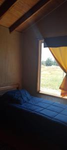 - une chambre avec un lit et une fenêtre dans l'établissement Cabaña cercana a bosque nativo Frutillar, à Puerto Octay
