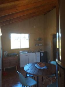 a kitchen with a table and chairs in a room at Cabaña cercana a bosque nativo Frutillar in Puerto Octay