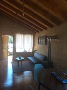 a living room with a couch and a table at Cabaña cercana a bosque nativo Frutillar in Puerto Octay