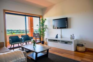 a living room with a tv and a couch and a table at Apartamento Panoramico - By Dalma Portuguesa in Branqueira