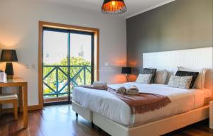 a bedroom with a large bed and a large window at Apartamento Panoramico - By Dalma Portuguesa in Branqueira +28 photos
