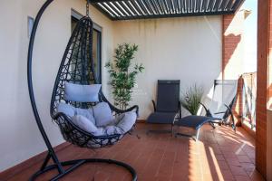 a hanging hammock on a patio with a chair at Apartamento Panoramico - By Dalma Portuguesa in Branqueira