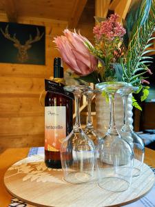 3 verres à vin et une bouteille de vin sur une table dans l'établissement Jodłowa Chata, à Myślenice