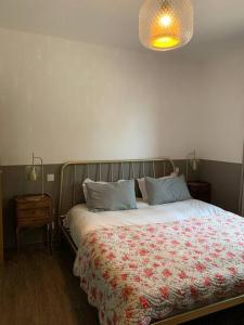 a bedroom with a bed with a floral comforter at "Villa I Rottani" Magnifique villa avec piscine privée in Aléria