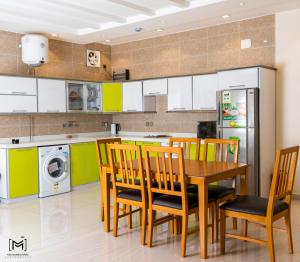 منتجع الكناري للفلل الفندقية الفاخرة Canary resort في الطائف: مطبخ مع طاولة وكراسي وثلاجة
