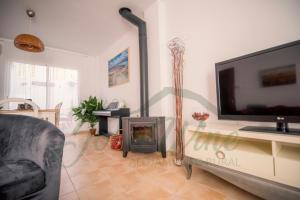 a living room with a fireplace and a flat screen tv at La casa de John Wine , Bornos (Spain) in Bornos