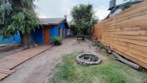 einen Hof mit einem Holzzaun und einer Bank neben einem Haus in der Unterkunft Casa Azul a 5 cuadras del centro y a 8 del mar in Villa Gesell