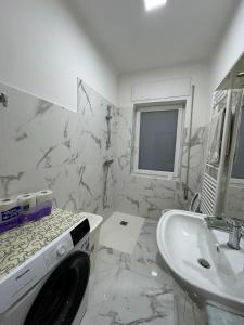 a white bathroom with a sink and a washing machine at Lavanda House in Vicenza