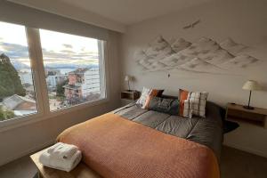 Un dormitorio con una cama grande y una ventana grande en AT Bariloche, en San Carlos de Bariloche