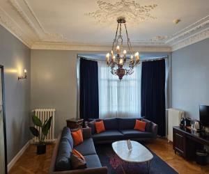 a living room with a blue couch and a chandelier at Lina Hotel Taksim Pera in Istanbul