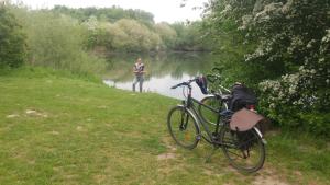 un hombre está de pie en el agua con una bicicleta en Messezimmer Laatzen APO 2, en Hemmingen