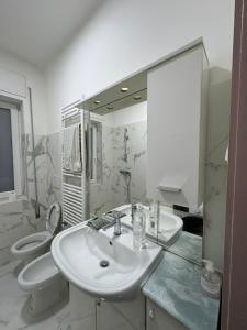 a bathroom with two toilets and a sink and a mirror at Lavanda House in Vicenza