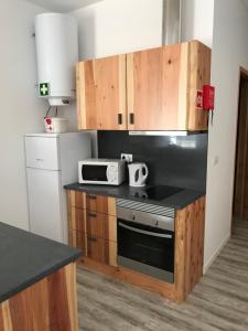 a kitchen with a stove and a microwave at Ninho do Monte in Ponta Delgada