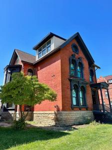 ein rotes Backsteinhaus mit einem Baum davor in der Unterkunft Stylish Cozy Studio in Detroit in Detroit