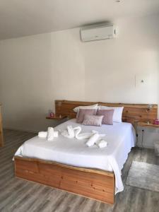 een slaapkamer met een bed met witte handdoeken bij Ninho do Monte in Ponta Delgada